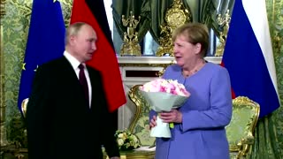 Putin gives Merkel flowers as they meet in Kremlin