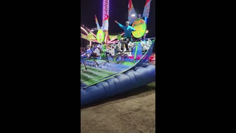 Talented guy at carnival climbs ladder backwards to win prize