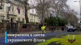 Protesters paint a Ukraine flag in the road opposite the Russian embassy in London.