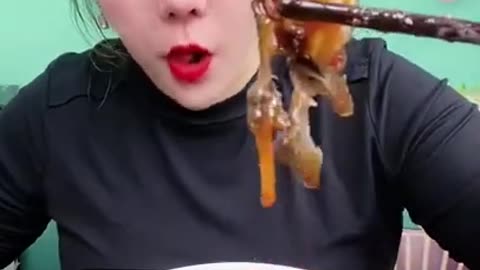 WOMAN EATING SPICY NOODLE WITH FAT MEAT