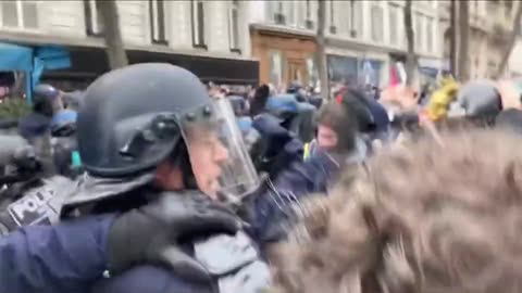 Police rush into a crowd protesting against President Macron