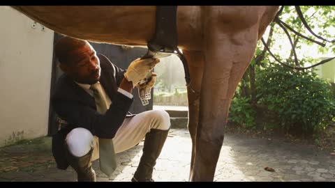 African American man installing the horse saddle