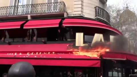 Protesters set fire to restaurant favoured by Macron and clash with police in Paris