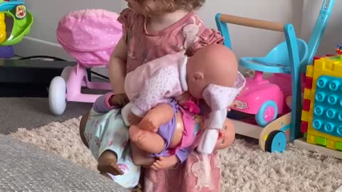 Little girl dances with her baby dolls
