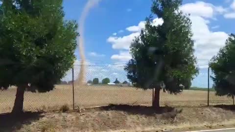 Person in Car Witnesses Dust Devil Originating From Field