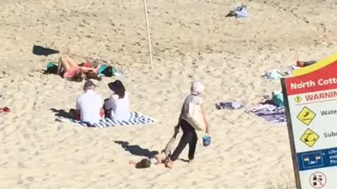 Uncooperative Child Dragged Along Beach