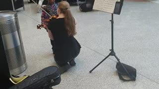 Lil Girl Stunned BY beautiful Violin Player in Airport