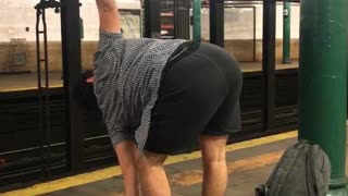 Barefoot man does yoga on subway platform