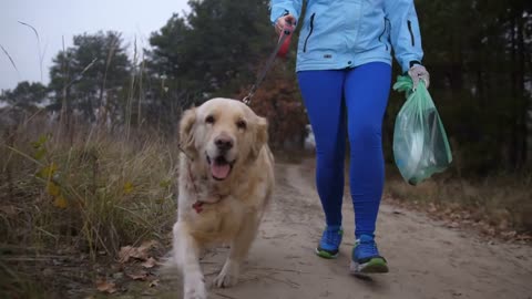 Low section of sporty fit female running with trash bag