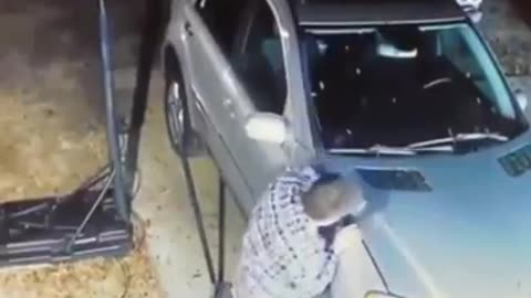 Man held his hand in the hood of the car.