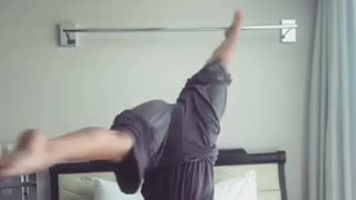 Woman in grey doing yoga falls off white bed