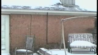 Dad Holding Baby Slips In The Snow On Patio