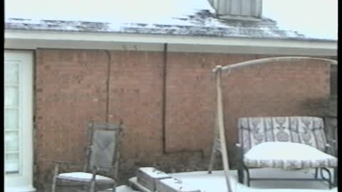 Dad Holding Baby Slips In The Snow On Patio