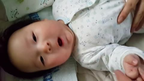 This is a video of a happy baby lying down and receiving a massage.