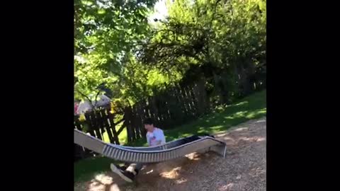Guy in white shirt falls off silver slide