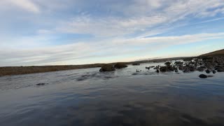 Calm river . Blue sky with a few clouds.