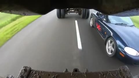 Miata driving underneath a Truck