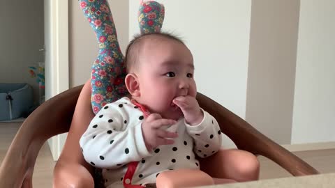 The baby is having fun listening to his father's animal sounds