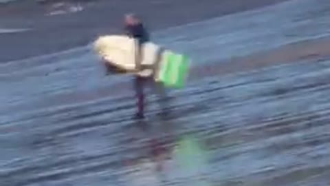 White surfboard guy walking across beach oh no