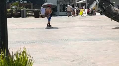 Guy orange hat skating shirtless umbrella
