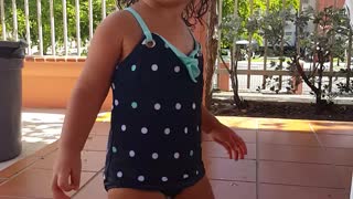 Little girl dances by the pool