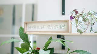 A Hand Placing a Sign with a Phrase on a Shelf