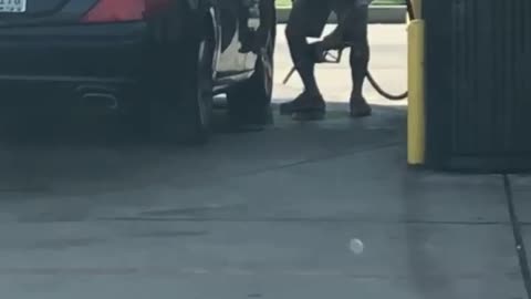Guy Using Gas at Gas Pump to Clean Car
