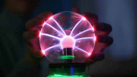 Hands pressing on an electric ball of light