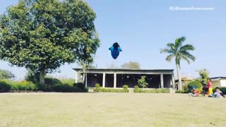 Blue shirt guy attempts double backflip on grass and falls
