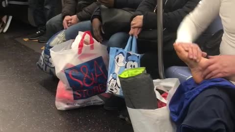Man gives foot rub to his wife on subway train