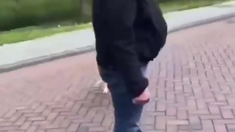 A European man is trying to walk his dog when a mob of African migrants