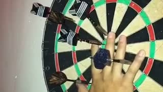 Slowmotion dart barely misses finger on board at night