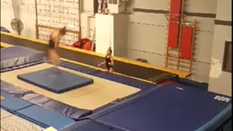 Girl in black misses flip on trampoline