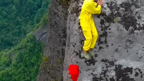 中国湖南峭壁飞人，薄如刀片的悬崖上帮游客烧香，日入万元，胆子太大了！