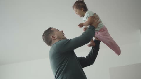 A Happy father Lifting a Laughing Baby Girl