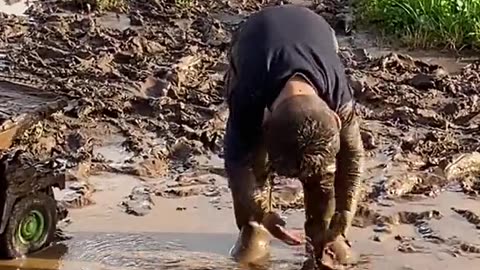 Boy Plays in Mud Puddle