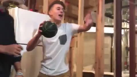 White shirt kid in basement dunks on shooting game basketball