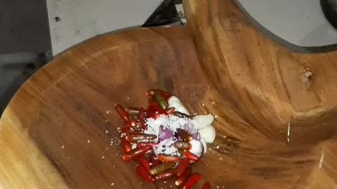 Make Sambal using a wooden spoon