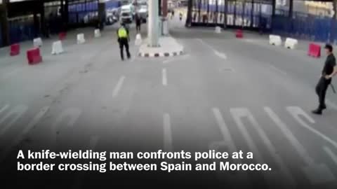 Spanish police throw traffic barrier at knife-wielding man