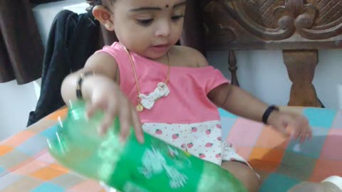 cute baby playing with 7up bottle