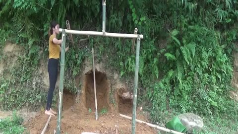 Dig the ground to make a duck coop and build it with bamboo poles