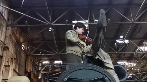 a soldier playing a musical instrument on a tank