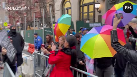 A protest against Drag Queen Story Hour at a NYC library is met with counter-protesters holding rainbow umbrellas