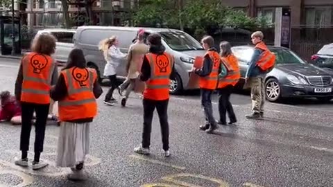 Furious motorist punches and kicks eco activist blocking a road in Central London