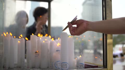 Lighting Candles At a Buddhist Shrine