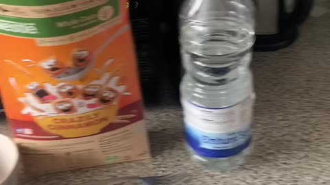 Man in a suit uses a fork to eat cereal with water instead of milk