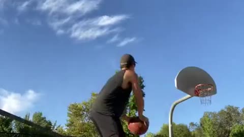 Guy Makes Two Basketball Trickshots While Balancing Himself Over Slackline and Rola-Bola