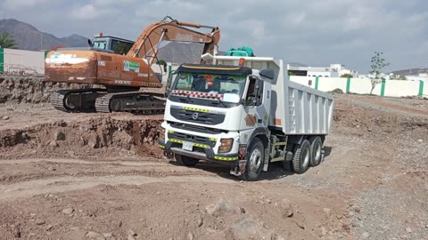 Excavator loading Volvo truck uae