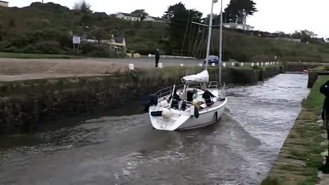 Yacht entering narrow harbour in rough seas, Courtown Harbour