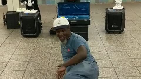 Man in blue shirt jeans dancing subway station